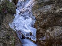 Skurrile Eisfigur über Fontäne zwischen Felsen